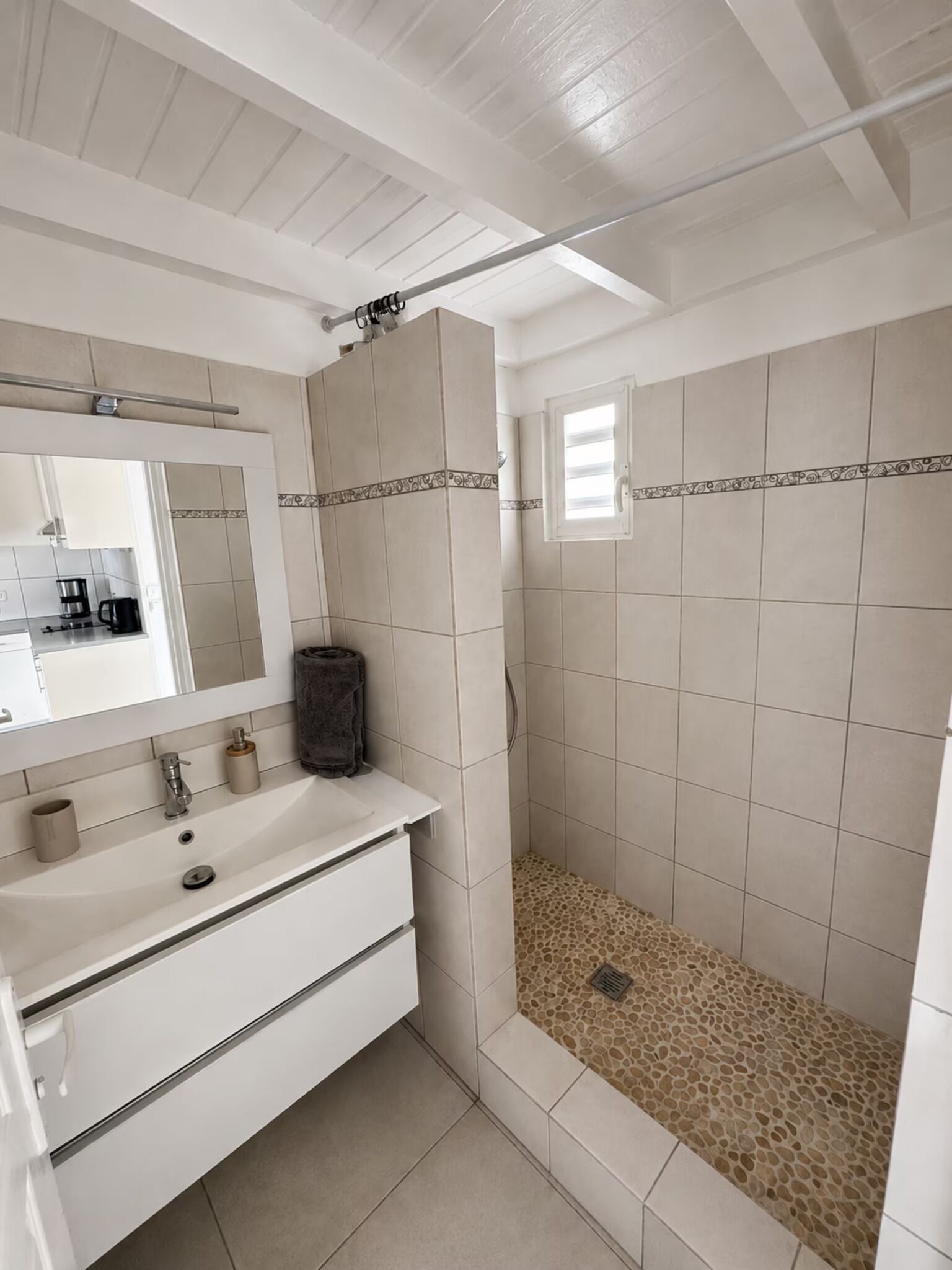 Ein Badezimmer mit Dusche, Waschbecken und Spiegel.