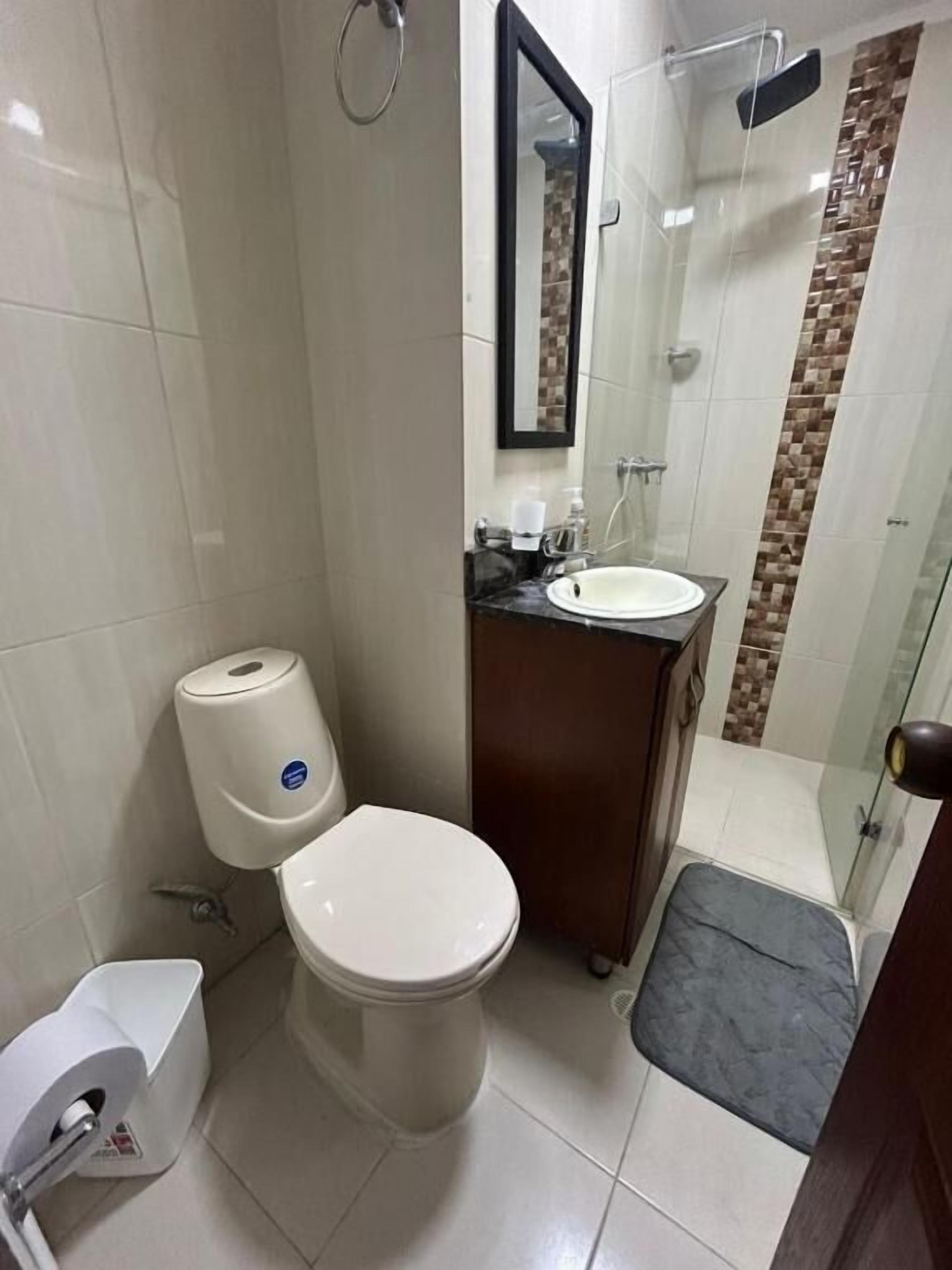 Ein Badezimmer mit Toilette, Waschbecken und Duschbereich.