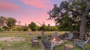 An outdoor seating area with chairs and a fire pit surrounded by trees. - Twisted Cedar Retreat - River views w/Firepit! (Ingram)