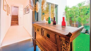 Ein modernes Interieur mit einer Holzbank, gerahmten Bildern an der Wand und Blick ins Freie.