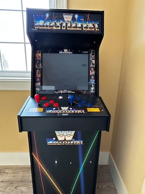 Eine Ringkampf-Spieltrommel mit Bildschirm, Joystick, Knöpfen und einem Logo.