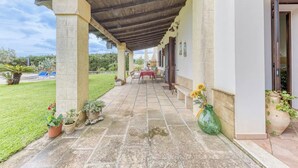 A covered patio with a table and chairs, potted plants, and a view of a swimming pool. - Villa Cisura Ranne - 2 km from the sea with a private heated pool (Puglia)