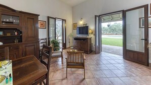 A spacious patio area with a dining table, chairs, a TV, and a cabinet. - Villa Cisura Ranne - 2 km from the sea with a private heated pool (Puglia)
