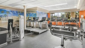 Ein Fitnessstudio mit Laufbändern, Crosstrainern und Gewichten.
