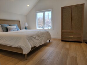 Une chambre à coucher avec un lit, une armoire, une fenêtre et une lampe.