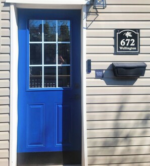 A blue door with a window, a mailbox, and a house number sign. - Stay in the heart of Toronto (toronto)