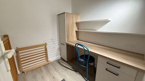 A small, well-lit room with a wooden desk, a chair, and a radiator. - Apartment with communal pool and parking (LA COUARDE SUR MER)