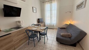 A compact living space with a kitchenette, dining area, and a sofa. - Apartment with communal pool and parking (LA COUARDE SUR MER)