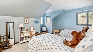 Ein Schlafzimmer mit einem Bett, einem Schaukelstuhl, einem Bücherregal, einer Uhr und einem Fenster.