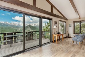 A spacious room with large sliding glass doors leading to a balcony with mountain views. - Sittin' Pretty Luxury Vacation Home at Windcliff (Estes Park)