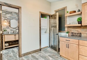 A kitchen with wooden cabinets, a sink, and a refrigerator. - Sittin' Pretty Luxury Vacation Home at Windcliff (Estes Park)