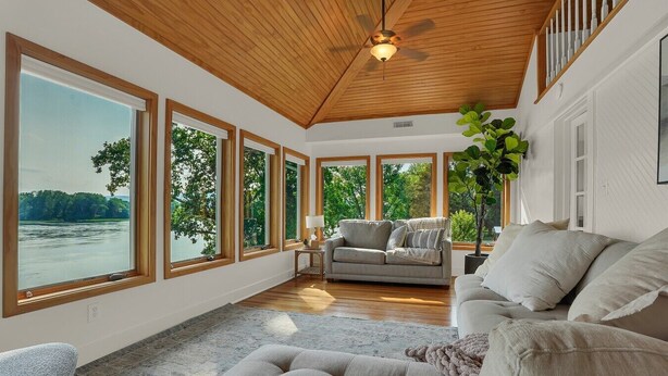 A spacious room with large windows, a ceiling fan, and a sofa. - Riverfront Manor - Beautiful view and setting! (Dauphin)