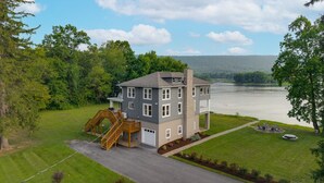 A multi-story house with a staircase, a garage, and a view of a lake. - Riverfront Manor - Beautiful view and setting! (Dauphin)