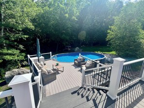 A deck with a pool, surrounded by trees. - NH Escape, 4 Bedroom, Pool, Hot Tub, Quiet Location (Goffstown)