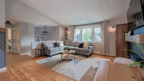 Een ruime woonkamer met een bank, salontafel en een televisie.