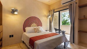A bedroom with a bed, a circular wall decoration, a balcony with a table and chairs, and an air conditioning unit. - Depto. Eek’ · 1 Hab · 1 Baño · Terraza Privada (Merida)