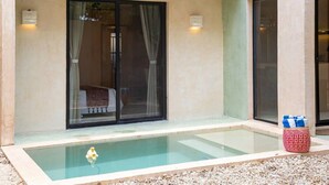 Zwembadgedeelte met een glazen omheining, een bed zichtbaar door het glas, en een decoratie object aan de zwemwaterkant.