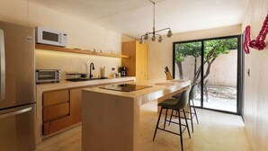 Een moderne keuken met een centraal eiland, een magnetron, een broodrooster en een koffiezetapparaat.