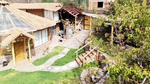A model of a traditional house with a tiled roof, a wooden porch, and a stone pathway leading to the entrance.
