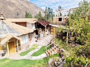 A model of a traditional house with a tiled roof, a wooden porch, and a stone pathway leading to the entrance.