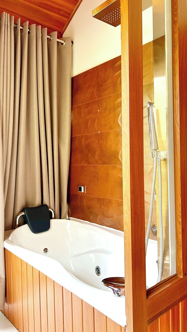A bathroom with a wooden panel wall, a bathtub, a shower, and a mirror.