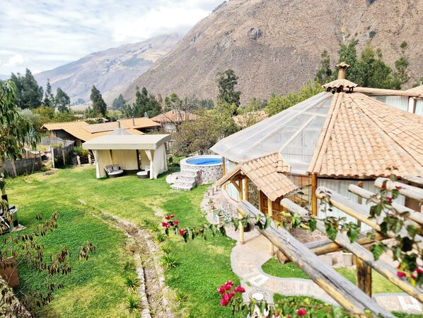 A rural property with a swimming pool, outdoor seating, and a view of mountains.