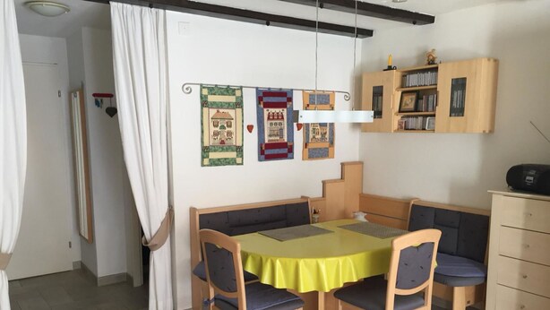 A dining area with a table, chairs, and a bookshelf. - Amici 13 Appartement/Fewo 2-Bettwohnung by Interhome (Saas-Fee)