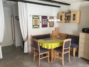 A dining area with a table, chairs, and a bookshelf. - Amici 13 Appartement/Fewo 2-Bettwohnung by Interhome (Saas-Fee)