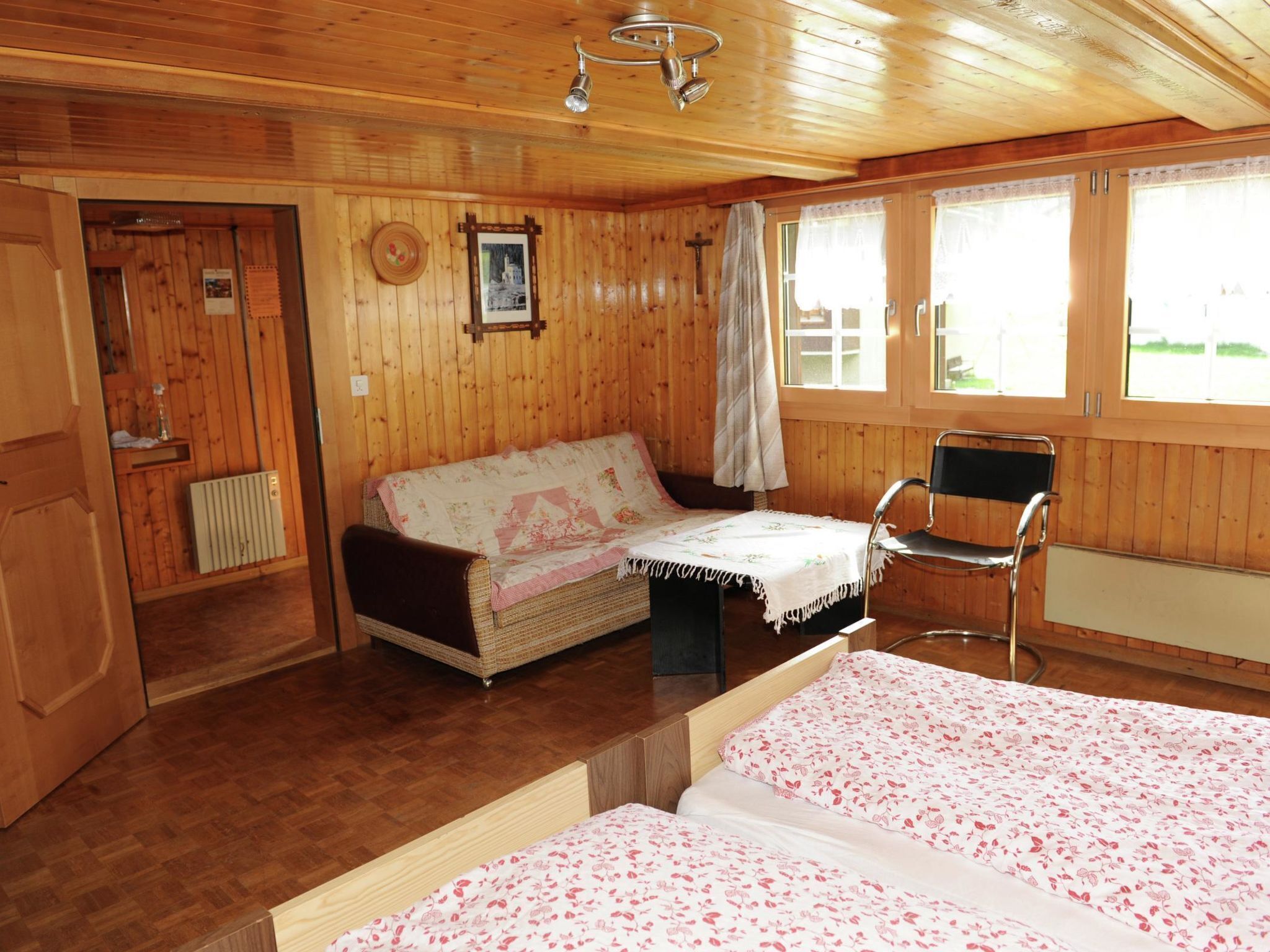 Een houten hut met twee bedden, een stoel en een klein tafeltje.