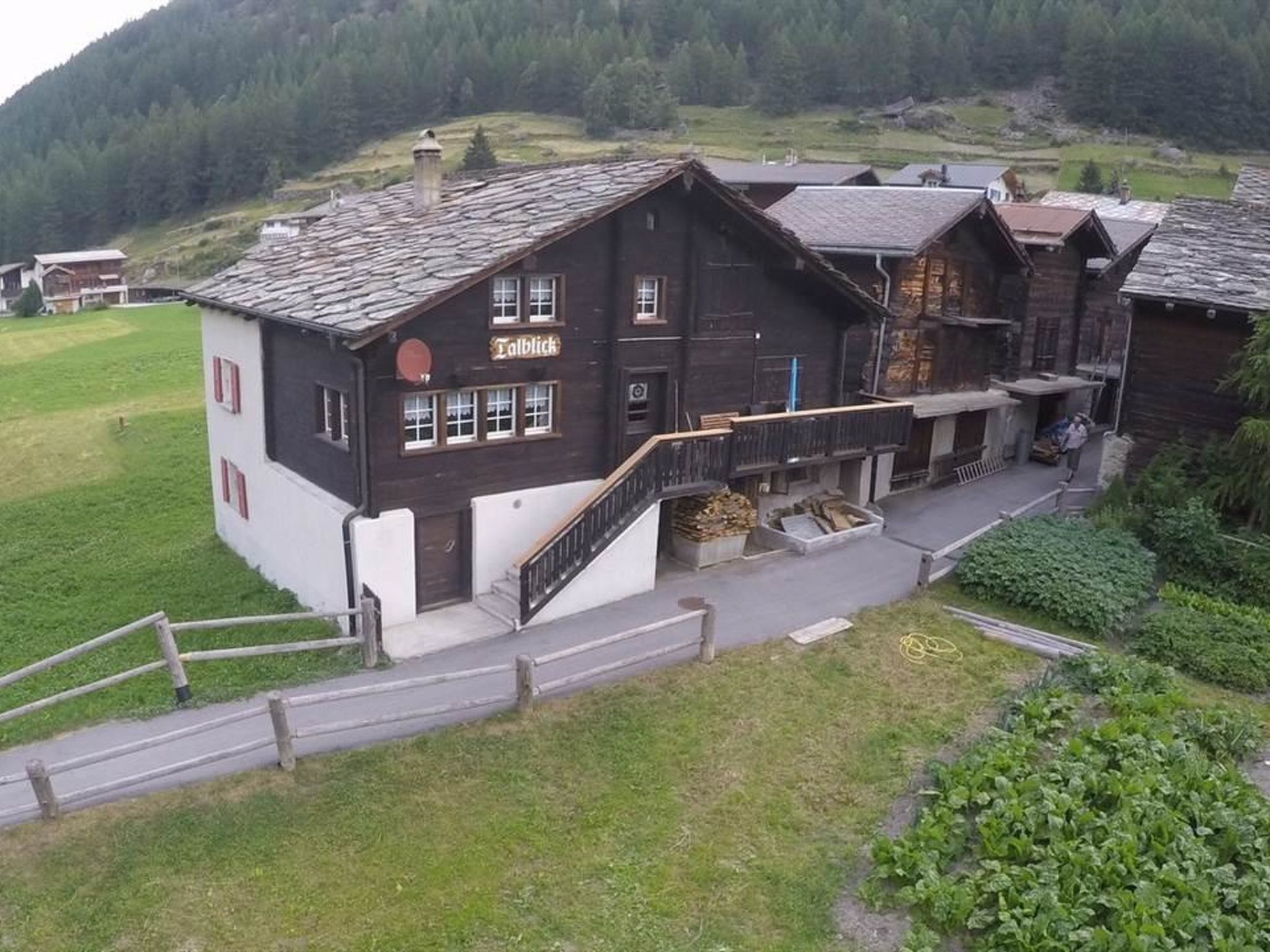 A traditional wooden building with a sign 'Talblick' and a staircase leading to the entrance.