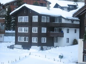 A multi-story building with a snow-covered roof, multiple windows, and balconies. - Mier Gfallt's Appartement/Fewo, Bad, WC, 3 Schlafräume 5-Bettwohnung by Interhome (Saas-Fee)
