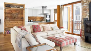 A living room with a sofa, ottoman, and a fireplace. - Sonnegg Lodge 2.2 Appartement/Fewo Appartement/Fewo by Interhome (Saas-Fee)