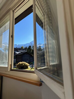 A window with a view of a mountain and a wooden cabin. - Bettina Wellness Appartement/Fewo, Dusche oder Bad Bettina 3 by Interhome (Saas-Fee)