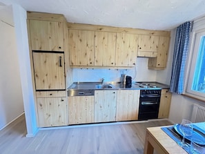 A modern kitchen with wooden cabinets, a stainless steel sink, and a built-in oven. - Bettina Wellness Appartement/Fewo, Dusche oder Bad Bettina 3 by Interhome (Saas-Fee)