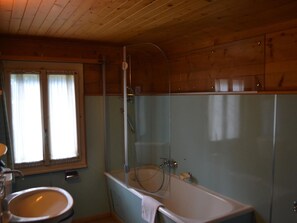 Ein Badezimmer mit Badewanne, Waschbecken und Duschkabine.