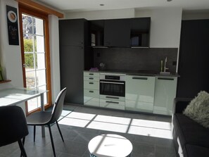 A modern kitchen with a dining area, a sofa, and a view of the outdoors. - Art Oase Appartement/Fewo 2-Bettwohnung by Interhome (Saas-Grund)