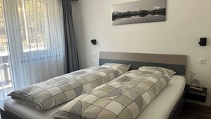 Un dormitorio con una cama, un cuadro en la pared y una mesita de noche con un adorno.
