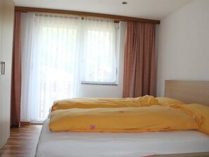Une chambre d’hôtel avec un lit, des rideaux et une fenêtre.