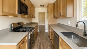 Una cocina moderna con armarios de madera, electrodomésticos de acero inoxidable y una encimera amplia.