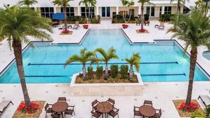 A hotel with a central pool, palm trees, and outdoor seating areas. - 24th Floor City View. Luxury Downtown Apartment, Pool, Spa, Gym, Free Parking. (Fort Myers)