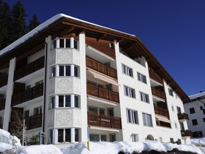 A multi-story hotel with balconies, a snow-covered roof, and a clear blue sky. - Chalchboda 1 Appartement/Fewo, Dusche und Bad, WC, 7-Bettwohnung by Interhome (Arosa)