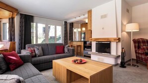A modern living room with a sofa, a wooden coffee table, and a fireplace. - Chalchboda 1 Appartement/Fewo, Dusche und Bad, WC, 7-Bettwohnung by Interhome (Arosa)
