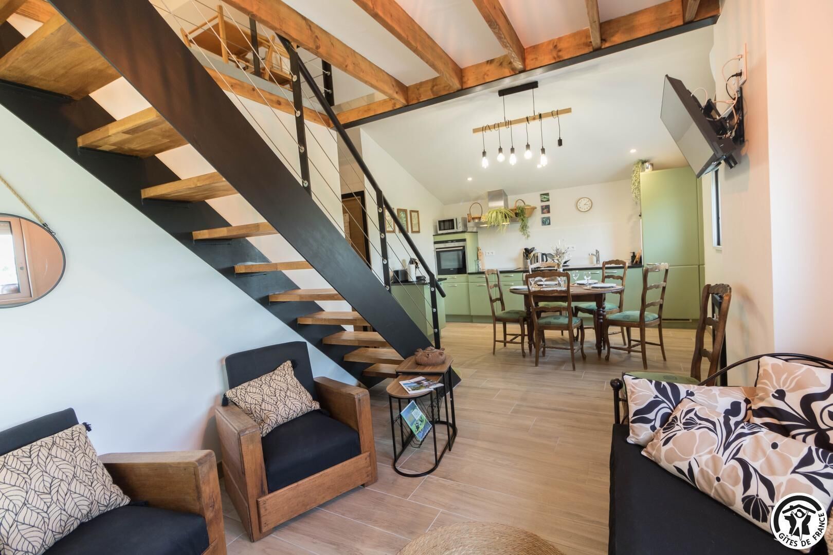A modern interior with a staircase, wooden furniture, a dining area, and a kitchen.