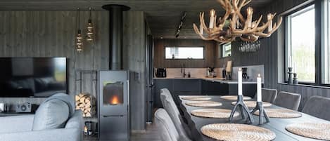 Un intérieur moderne avec une cheminée, un coin repas et une cuisine.