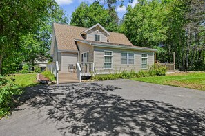 A single-story house with a front porch, a driveway, and a well-maintained lawn. - Soaking Bear Chalet • Hot Tub & Lake Access (Blakeslee)