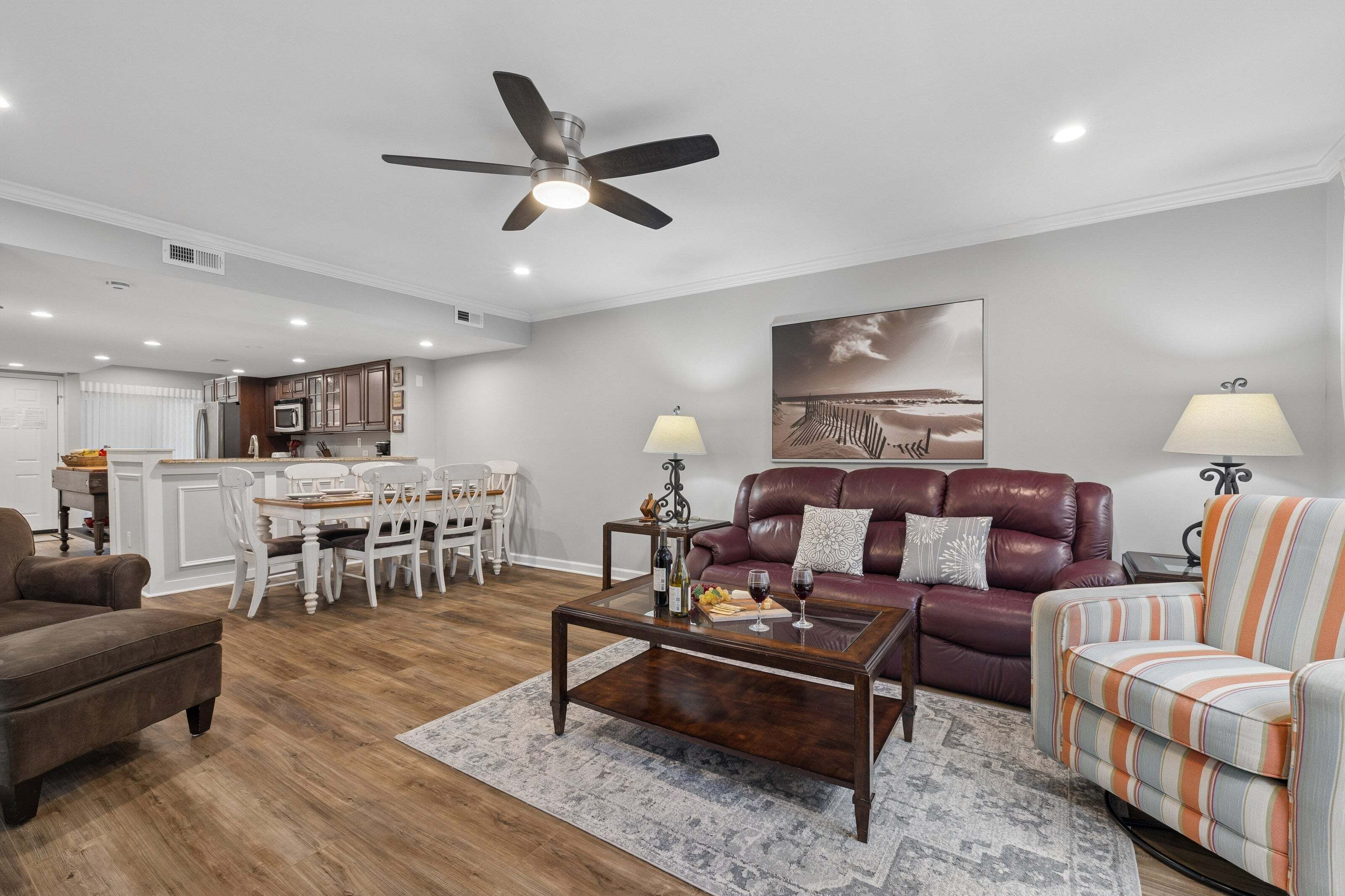 A modern living room with a sofa, armchair, coffee table, and dining area.