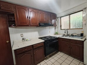 Una cocina con gabinetes de madera, una estufa y un ventanal con vistas.