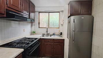 Une cuisine équipée d’une cuisinière, d’un four, d’un évier et d’un réfrigérateur.