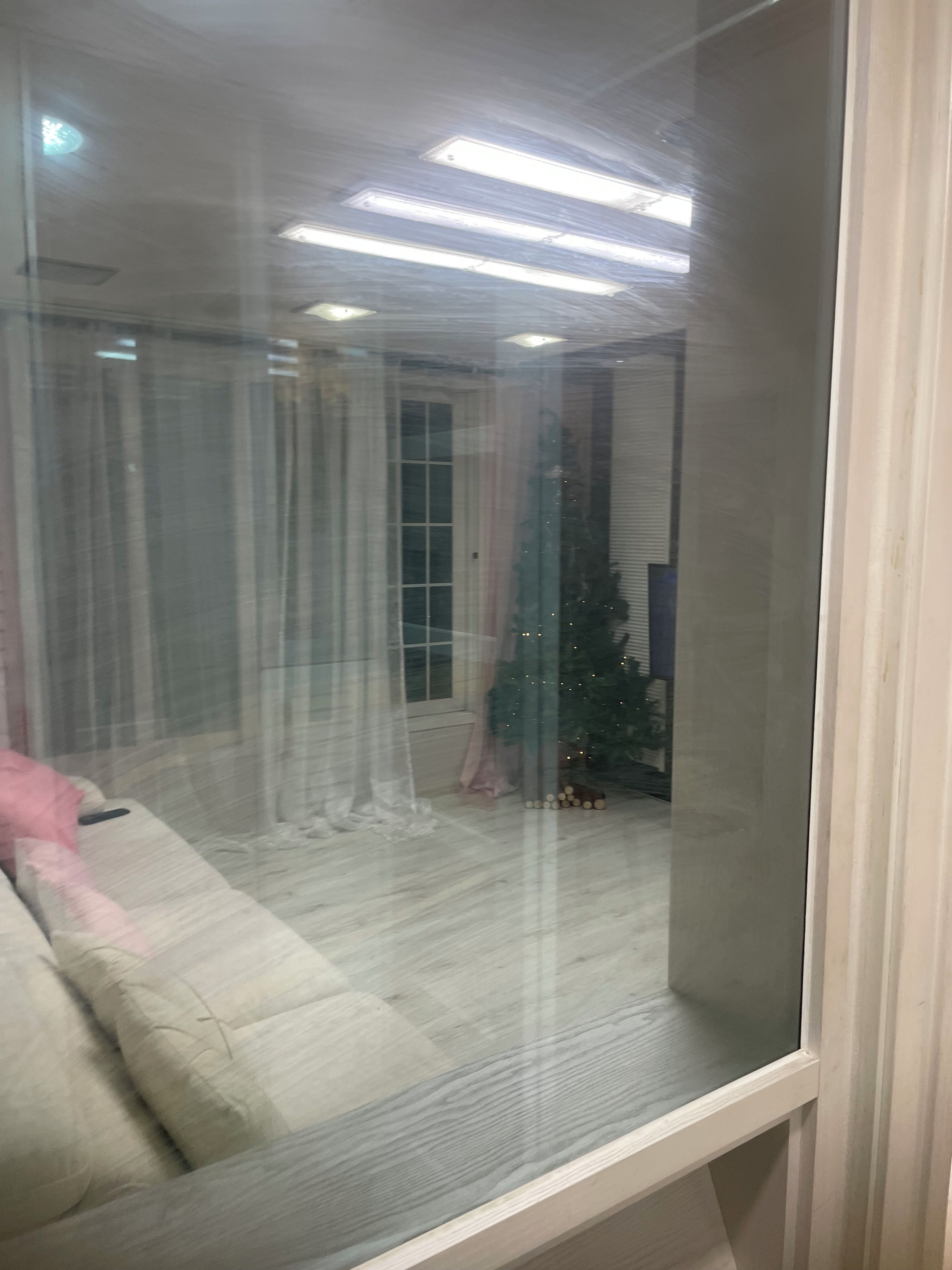 Una habitación con cama, ventana, árbol de Navidad y cortina.