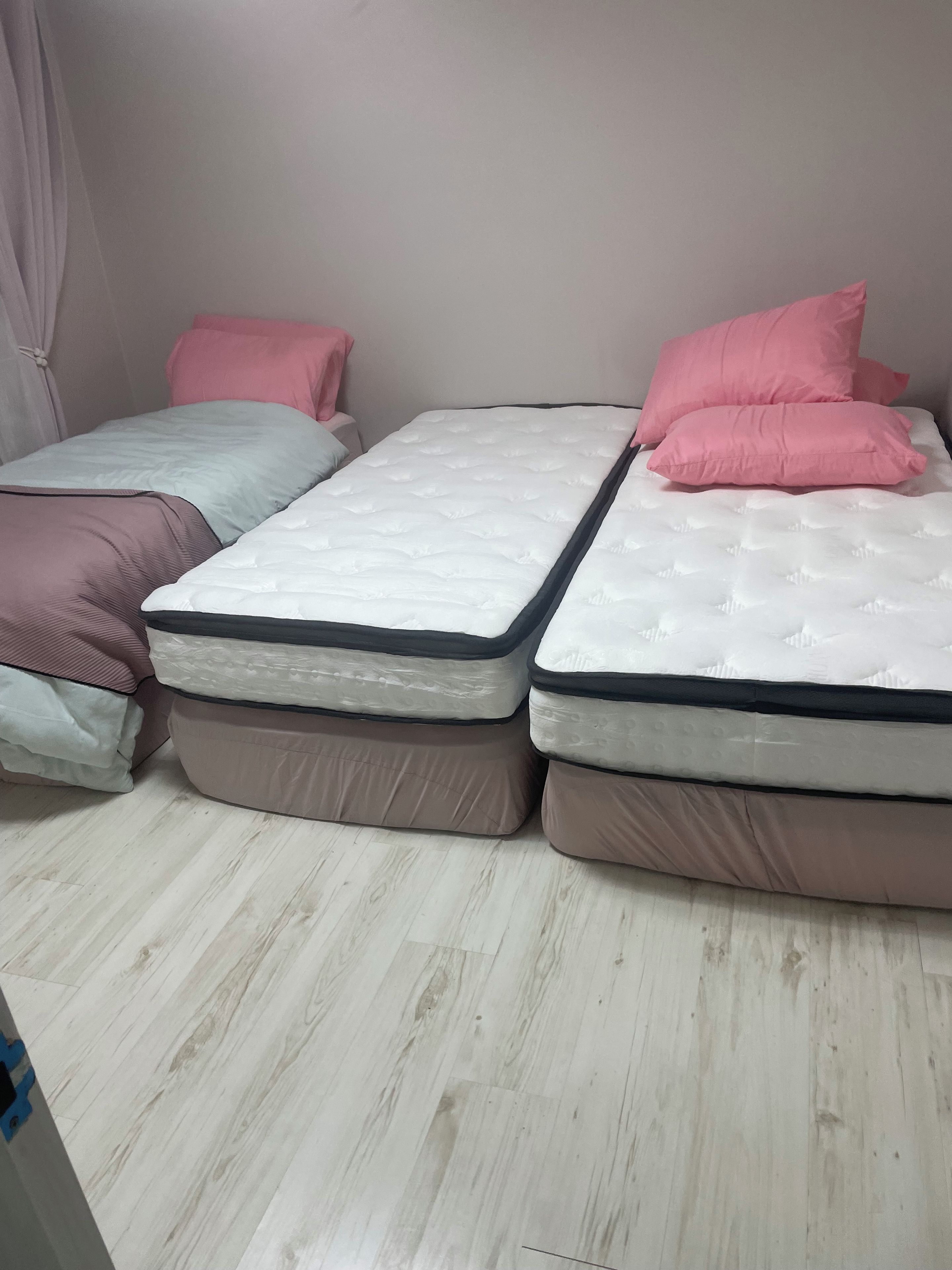 Una habitación con dos camas, cada una con colchón y almohadas.